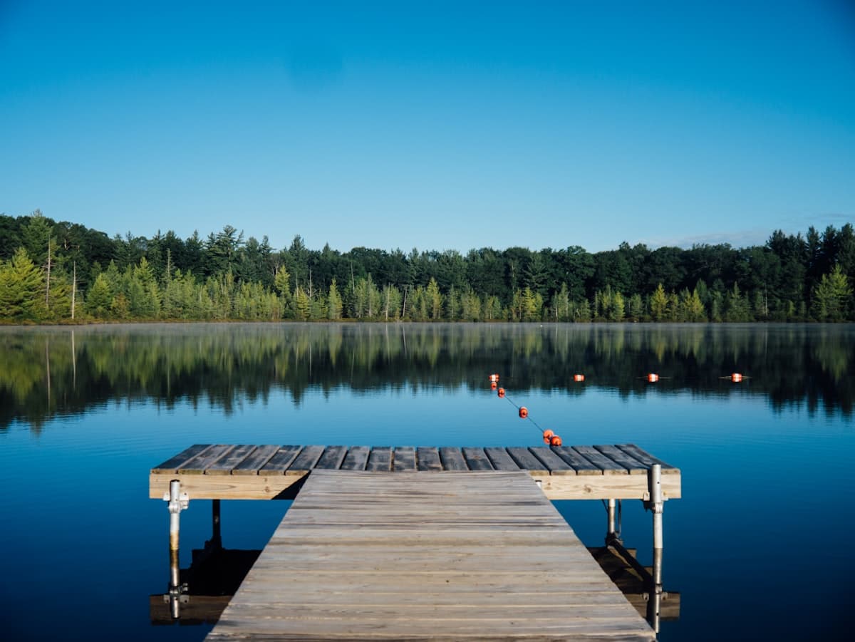 A calm dock on a still lake under a clear sky, representing a secure, peaceful future