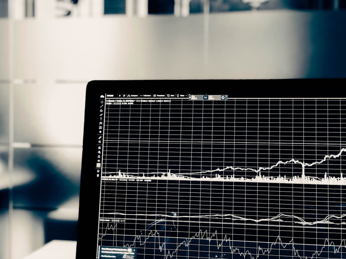 Dark monochrome screen showing an upward-trending stock chart